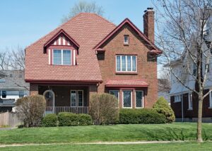 Brick House with Red Shingle Roof.