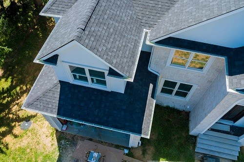 Rooftop in a new home constructed showing asphalt shingles multiple roof lines with aerial view.