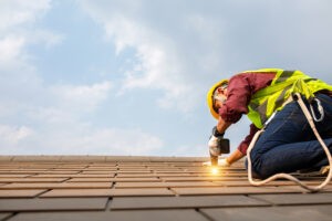 Worker on roof making repairs
