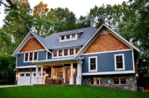 Large home with wooden cedar shake siding and blue horizontal siding