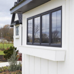 Close-up of home with white board-and-batten siding and black window frames